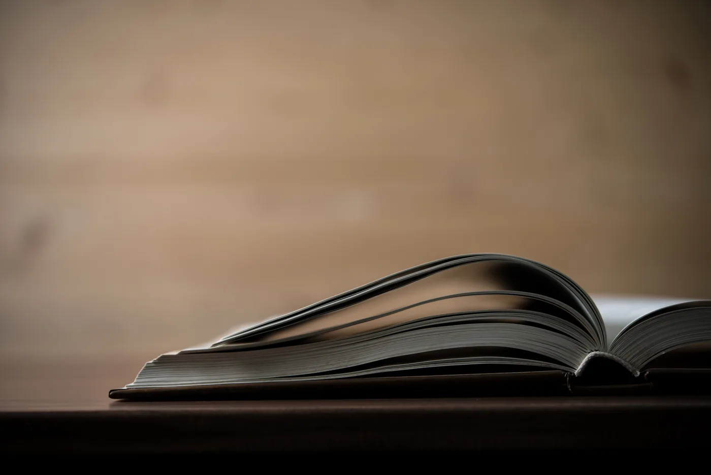 An open book resting on a wooden table